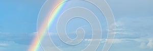 Beautiful colorful rainbow on blue sky. Banner size.