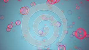 Beautiful colorful soap bubbles illuminated by pink light fly indoors on a blue background. Round bubbles float in the