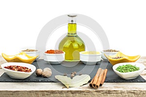 Beautiful colorful spices in bowls on slate tray, olive oil and salt. Free space for your text