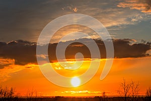 Beautiful colorful sunrise at the sea with dramatic clouds and sun shining. Dramatic sunset sky with orange colored clouds and sun