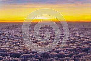 Beautiful and colorful sunset above purple color clouds. Looking through an airplane window.