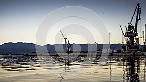 Beautiful and Colorful Sunset at the harbor of Rijeka with urban industry and cargo flair in Croatia