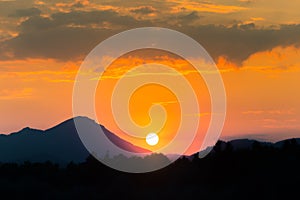 A beautiful, colorful sunset landscape with lake, mountain and forest. Natural evening scenery over the mountain lake in summer.