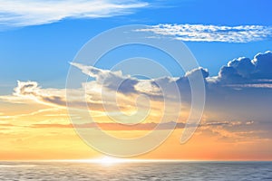 Beautiful colorful sunset at the sea with dramatic clouds and sun shining, blue sky ,twilight time