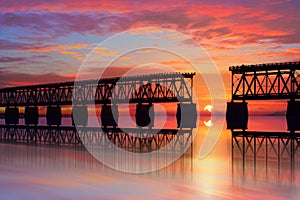 Beautiful colorful sunset or sunrise with broken bridge and cloudy sky