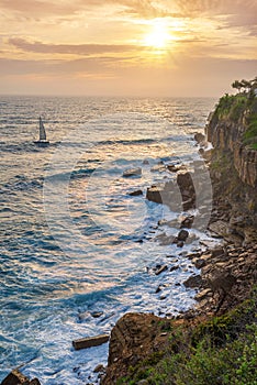 Beautiful colorful sunset and vivid dramatic sky at rocky shore of the Atlantic ocean