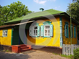 Beautiful colorful ukrainian village house exterior with red porch and green, white windows with shutters