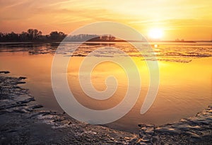 Beautiful colorful winter landscape with frozen lake and sunset