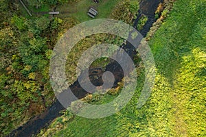 Beautiful colors of autumn. Forest, meadow and river photographed with a drone on sunny day.