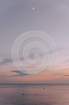 Beautiful colors at sunset in ibiza on the sea. People doing paddle surf with a nice image