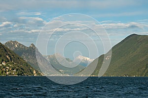 Lugano, Switzerland - October 6th 2021: Lago di Lugano with surrounding hills and mountains in the afternoon sunlight. photo