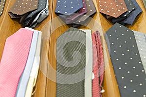 Beautiful colourful neckties on dark brown wooden background