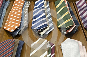 Beautiful colourful neckties on dark wooden background