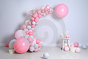 Beautiful composition with balloons and sweets near light wall