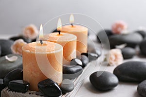 Beautiful composition with candles and spa stones on table