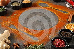 Beautiful composition with different spices, silhouettes of cutlery and plate on grey table, closeup