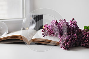 Beautiful composition with opened book and lilac flowers. Romantic wallpaper.