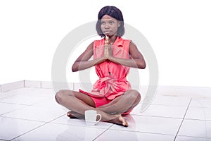 Beautiful young woman sitting on the ground crossing her feet with folded hands
