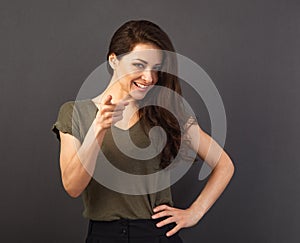 Beautiful confident excited smiling business woman showing the finger on camera maiking the choice on grey background with empty