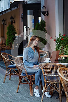 Beautiful confident woman. Woman on the street at the table . Business consultant, to note down, to make notes. Business