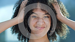 Beautiful confident young African girl smiling. Happy ethnic American female student curly afro hairstyle smiles, shows