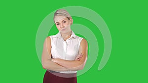 Beautiful confident young businesswoman standing with hands folded on a Green Screen, Chroma Key.