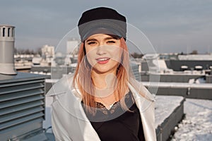 Beautiful confident young female engineer architect designer on rooftop of construction site looking at camera and smiling. Close-