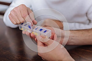 Beautiful convenient pill box being in the hands of a senior person