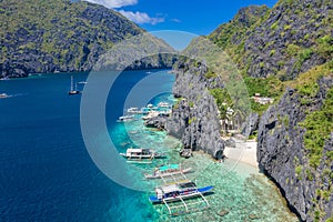 Beautiful coral reef, boats and a clear ocean on Matinloc Island, Bacuit Archipelago, El Nido, Palawan, Philippines