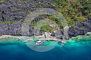 Beautiful coral reef, boats and a clear ocean on Matinloc Island, Bacuit Archipelago, El Nido, Palawan, Philippines