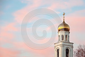 Beautiful coral sky in the rays of the setting sun over the Russian Orthodox Church