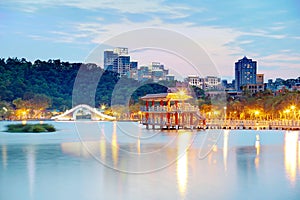 A beautiful corner of Dahu Community Park with a traditional arch bridge and an oriental pavilion by the lake