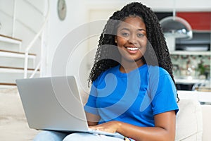 Beautiful corpluent black female student shopping online at computer