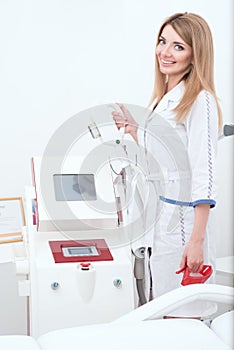 Beautiful cosmetician at her working place is going to apply procedure of laser epilation or rf lifting