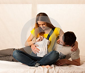 Beautiful coule - young man and pregnant woman resting on bed h