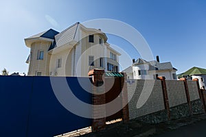 Beautiful country house behind a high fence. Chic cottage in a holiday village.