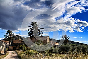 Beautiful country house in Hondon de las nieves, Alicante province, Spain, under cloudy sky and surrounded by vegetation.