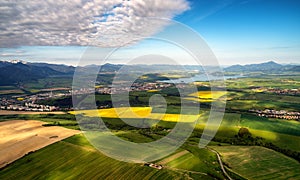 Beautiful country landscape with green, yellow fields and lake at background. Liptov, Slovakia