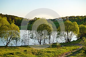 Beautiful countryside landscape. Green meadow and river in the evening. Summer. Russia