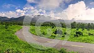 Beautiful countryside road in green field under blue sky