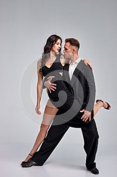 beautiful couple in active ballroom dance, dressed in classic black suit and dress