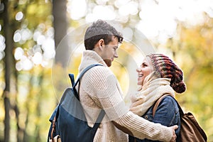 Beautiful couple in autumn nature against colorful autumn forest