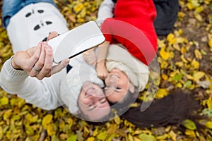 Beautiful couple in autumn park lying on the ground