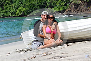 Beautiful couple at the beach with a boat, happy expressions gorgeous woman and latin guy at Costa Rica.