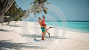 beautiful couple on the beach ready for snorkeling activities in maldives