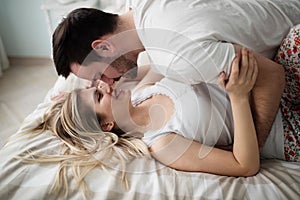 Beautiful couple being romantic and passionate in bed