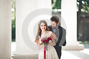 Beautiful couple, bride and groom posing near big white column