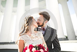 Beautiful couple, bride and groom posing near big white column