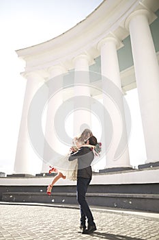 Beautiful couple, bride and groom posing near big white column