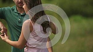 Beautiful couple dance in the field. the enjoy each other and smile. Summer weather. Romantic atmophere. slow motion